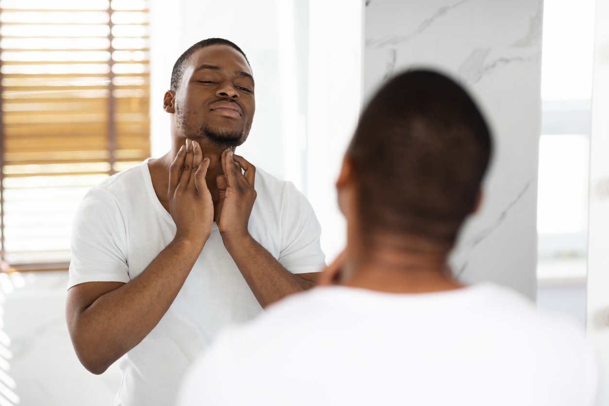 Man feeling swollen lymph nodes under his jaw