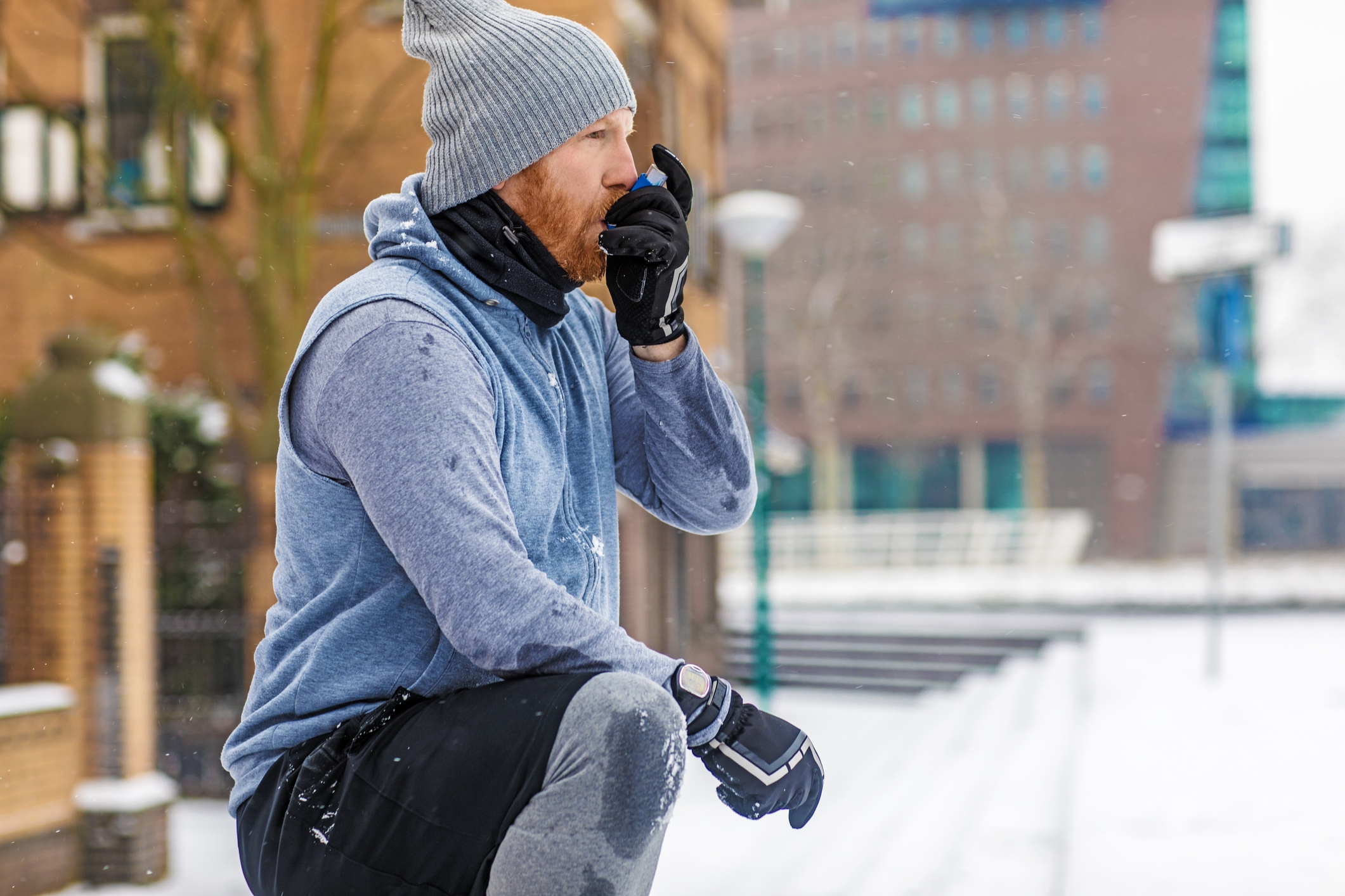Man using an inhaler for asthma symptoms in winter