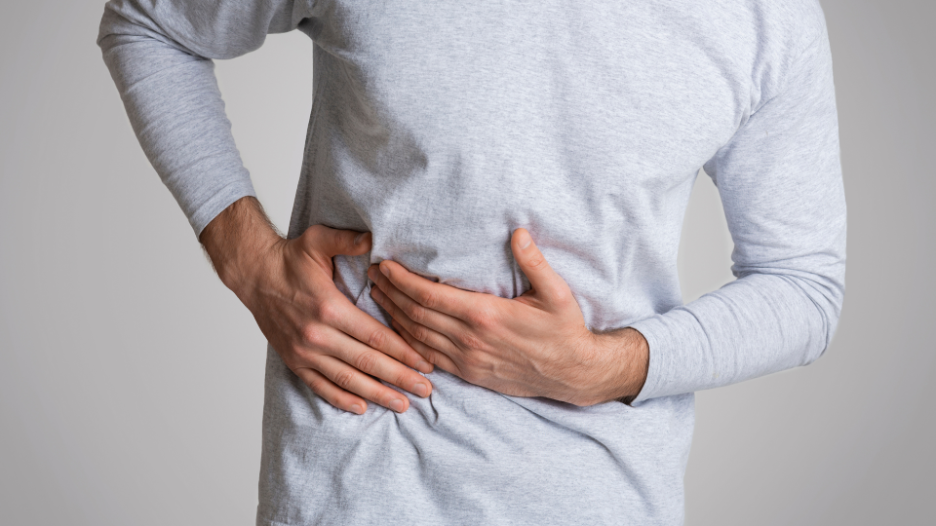 Person clutching his side from experiencing severe liver pain