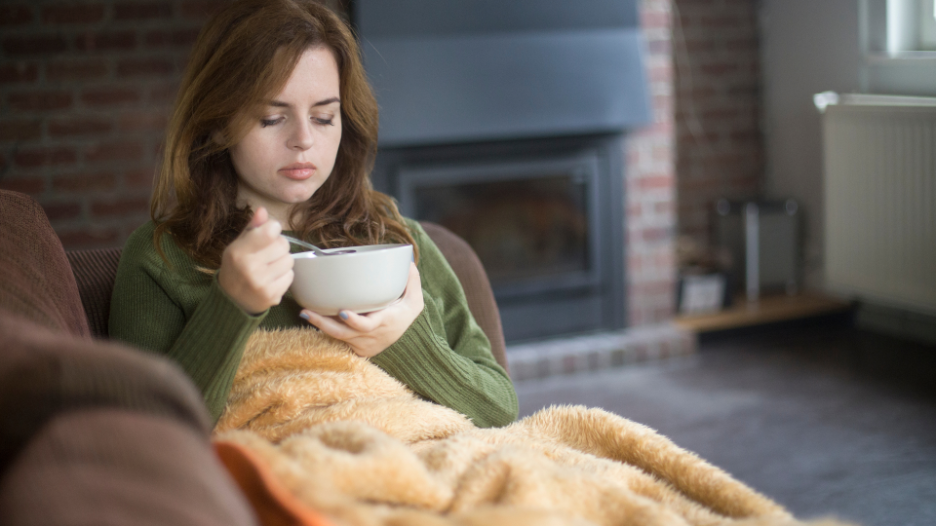 Woman eating soup when sick