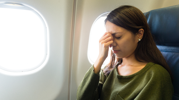 Woman flying while experiencing motion sickness symptoms