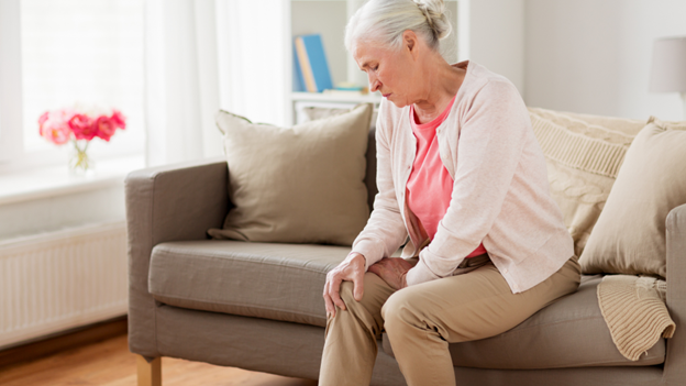 Woman holding knee because of constant knee pain