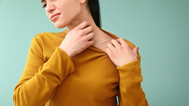 Woman breaking out in hives itching her neck