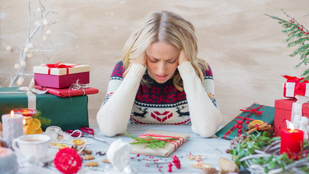 Woman sitting at a table experiencing holiday stress