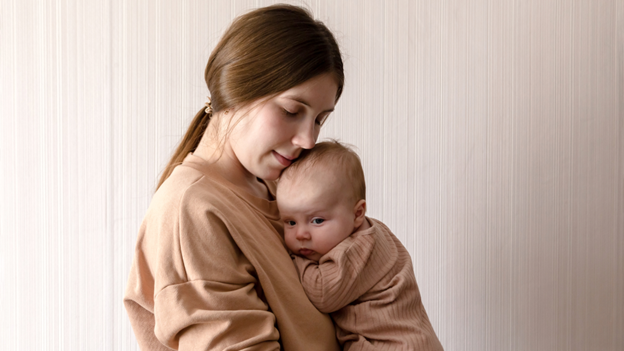 A mother holding her baby with heat rash close