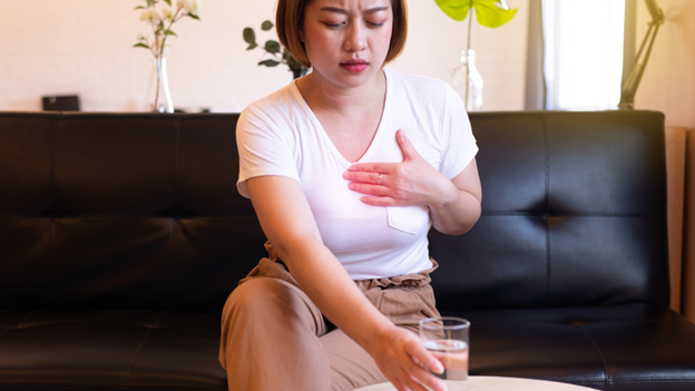 A woman reaching for a glass of water to get rid of acid reflux fast