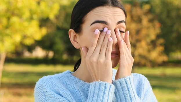 A woman rubbing her eyes after experiencing worse allergies than normal