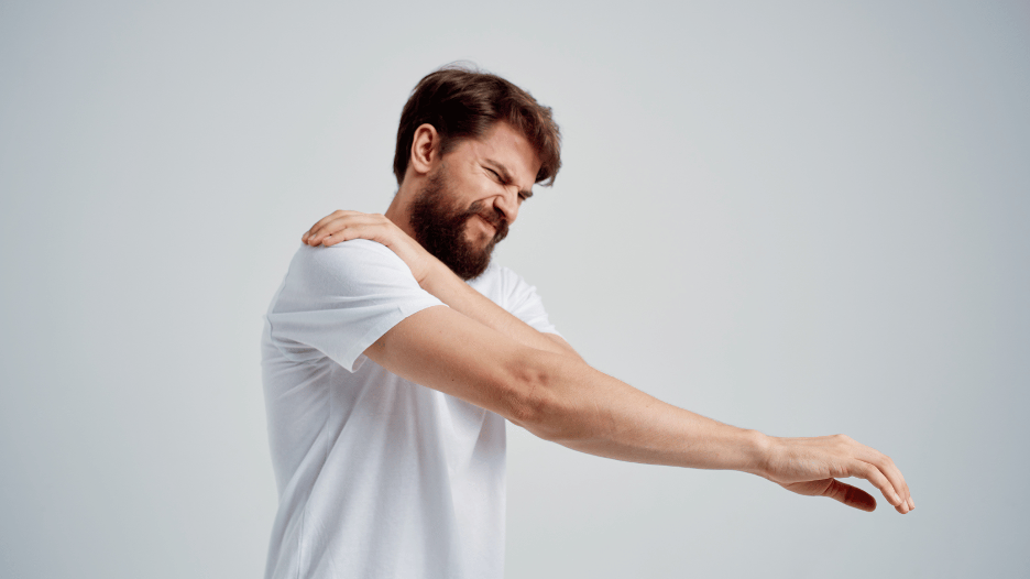 Man with shoulder muscle strain grimacing in pain