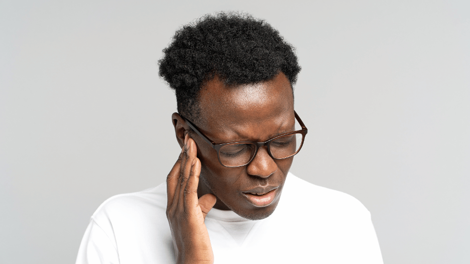 Man experiencing ear pain, holding his ear in discomfort, indicating the need for earache relief