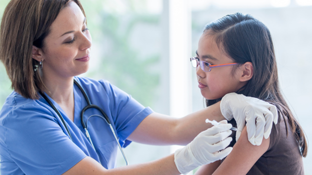 CityMD healthcare professional administering a flu shot to a young girl, emphasizing the importance of vaccination for flu prevention at any stage of flu season