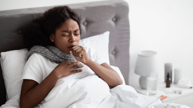 A woman in bed dealing with a cough that won’t go away