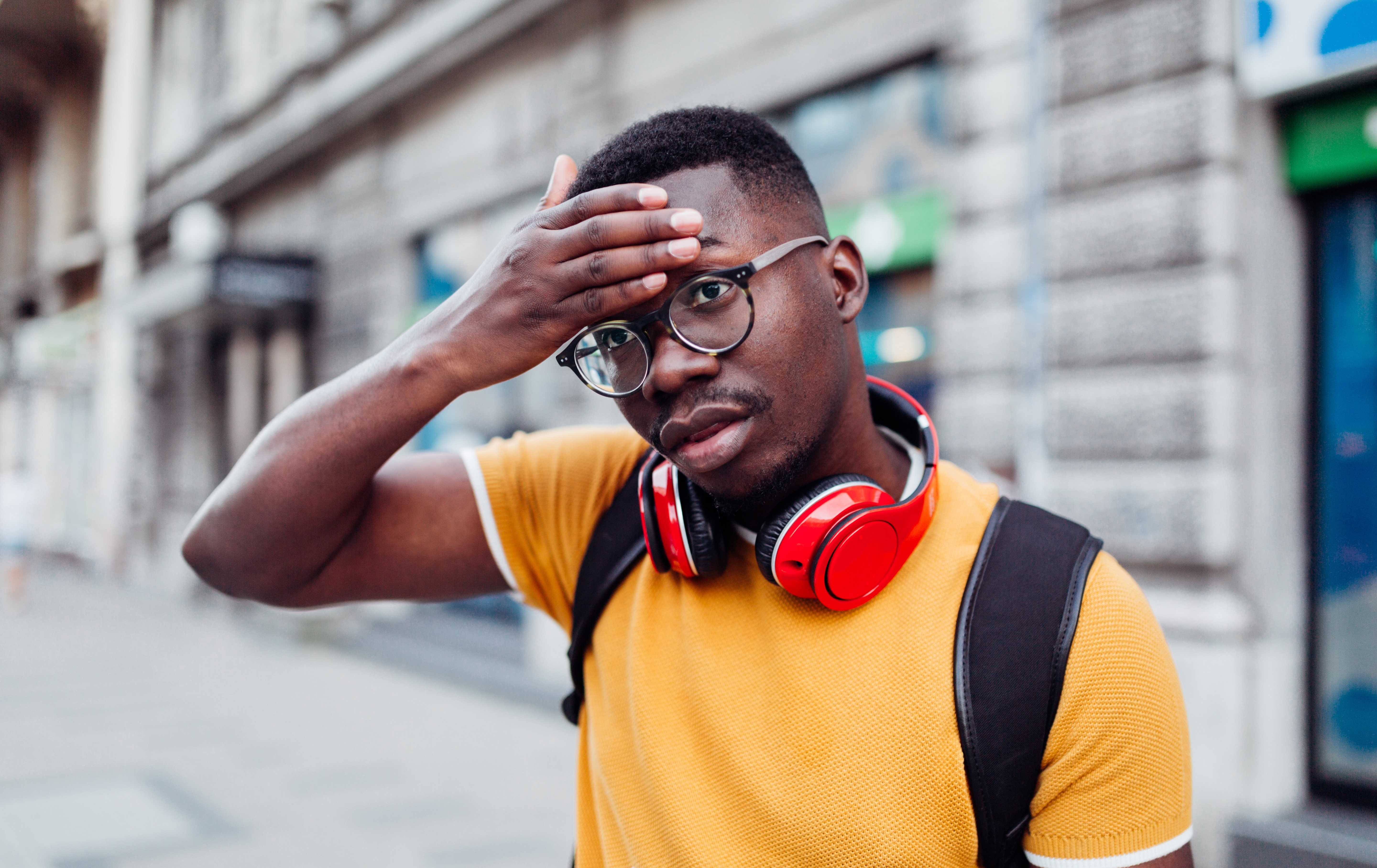 Man feeling feverish on sidewalk