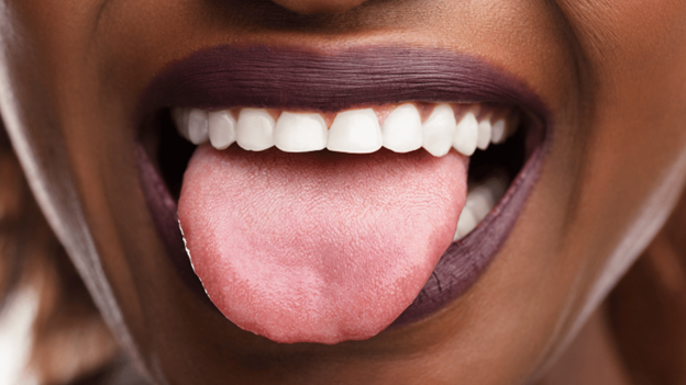 Close-up of a person sticking out their tongue, highlighting possible causes of tongue tingling, numbness, or burning sensations